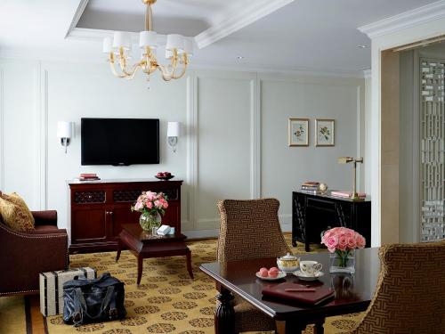 a living room with a television and a table and chairs at The Langham, Shenzhen in Shenzhen