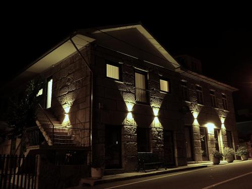 a building with lights on the side of it at night at Casa Máximo in Penafiel