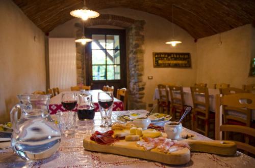 a table with a plate of food and glasses of wine at Agriturismo il posto delle fragole in San Giovanni Bianco