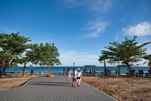 a group of people walking down a sidewalk near the beach at Avatara Condo B24 by malai in Mae Pim