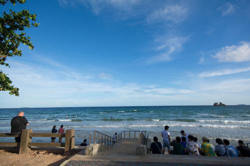 a group of people sitting on the stairs at the beach at Avatara Condo B24 by malai in Mae Pim