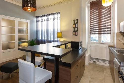 - une cuisine avec un bureau, une table et des chaises dans l'établissement Au coeur du centre historique, à Avignon