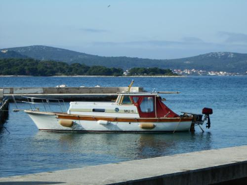 a boat is docked at a dock in the water at Senkini Dvori in Sutomišćica