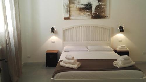 een slaapkamer met een bed met handdoeken erop bij Cardìlle Apartment in Monopoli