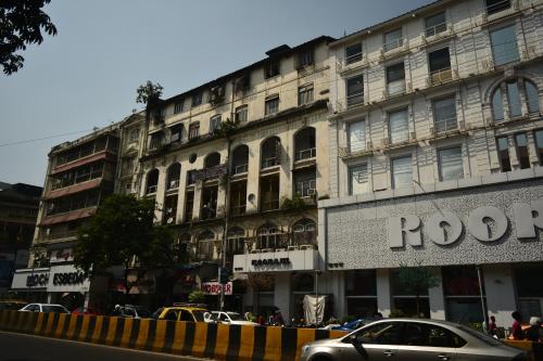 un edificio con un'auto parcheggiata di fronte di Hostel Vasantashram CST Mumbai, Free Wifi with 1940s Retro vibe a Mumbai