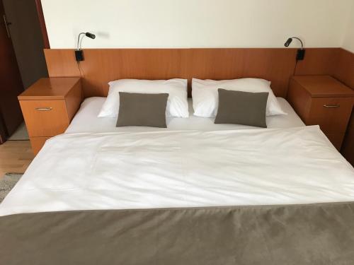 a large bed with white sheets and two pillows at Pansion Danica in Rastovača