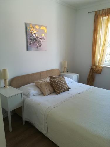 a bed with two pillows on it in a bedroom at Soba Mirus in Cavtat