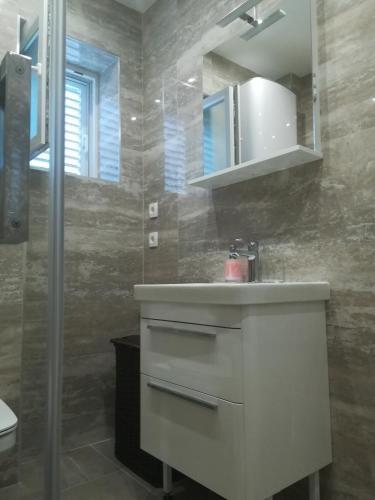 a bathroom with a white sink and a shower at Soba Mirus in Cavtat