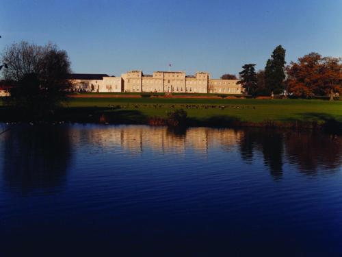 a large castle with a lake in front of it at De Vere Wokefield Estate in Reading