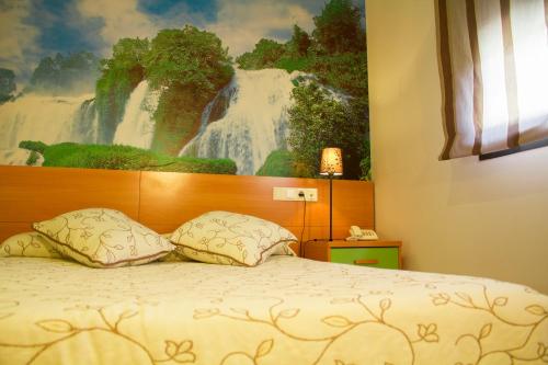1 dormitorio con 1 cama con una pintura en la pared en Hotel Restaurante Caracho, en Corella