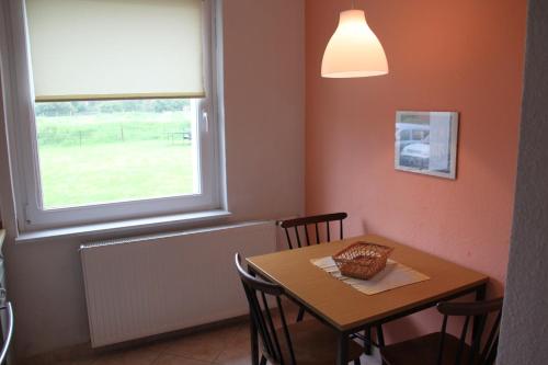 a dining room with a table and a window at Haus Marinus in Puttgarden