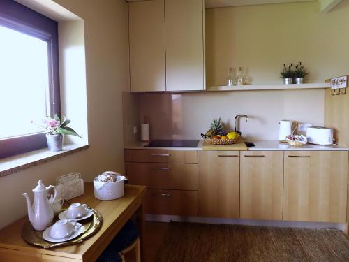 a kitchen with wooden cabinets and a table and a sink at Casa Máximo in Penafiel