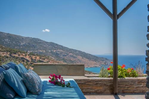 a blue couch with flowers on a patio at Aegean Castle Andros – Adults Only in Agia Eleousa