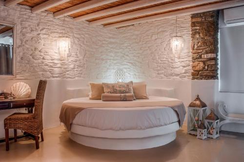 a bedroom with a bed and a table and a desk at Aegean Castle Andros – Adults Only in Agia Eleousa