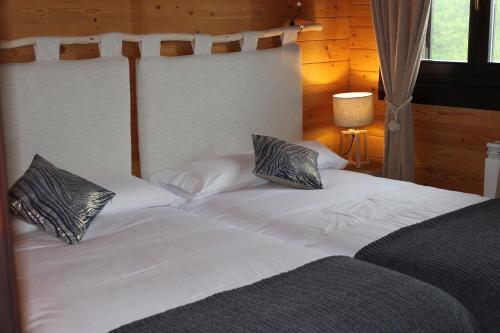 a large white bed with two pillows on it at Piedrafita Mountain in Piedrafita de Jaca