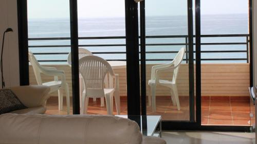 ビリャホヨサにあるPlaya Paraíso 48Dのリビングルーム(椅子2脚、ソファ付)