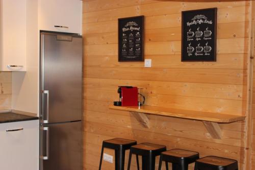 a bar in a kitchen with wooden walls and stools at Piedrafita Mountain in Piedrafita de Jaca
