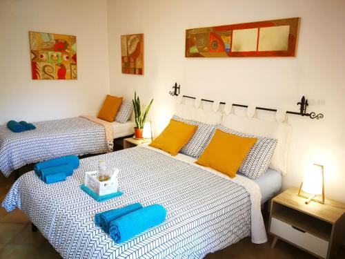アルゲーロにあるAcqua Chiaraのベッドルーム1室(ベッド2台、青と黄色の枕付)