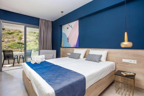a bedroom with a large bed with a blue wall at Madison Boutique, Faliraki in Faliraki