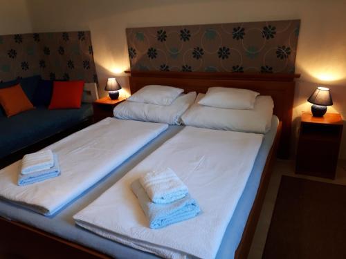 two beds in a hotel room with towels on them at Hungarian Farmhouse in Zákányszék