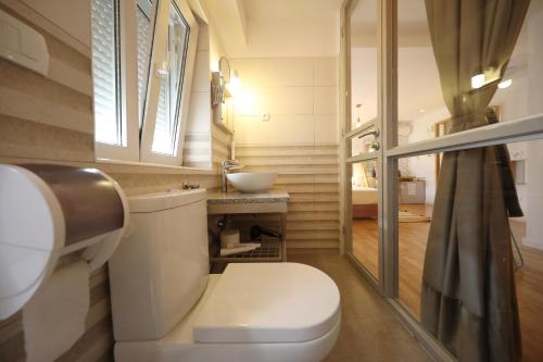 małą łazienkę z toaletą i umywalką w obiekcie Central Apartments Integrated Hotel w mieście Zadar