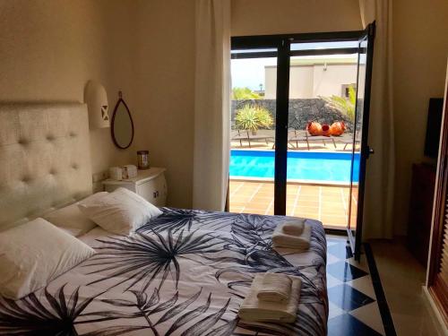 1 dormitorio con cama y vistas a la piscina en Villa Mici, en Playa Blanca