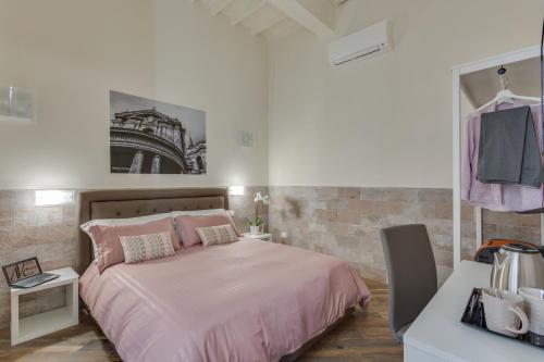 una camera con letto rosa e muro di mattoni di Navona Charme Suite a Roma