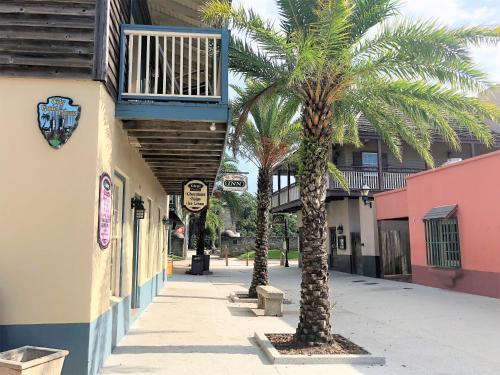 two palm trees on a sidewalk next to a building at St George Inn - Saint Augustine in Saint Augustine