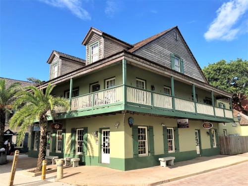 a green building with a balcony on a street at St George Inn - Saint Augustine in Saint Augustine