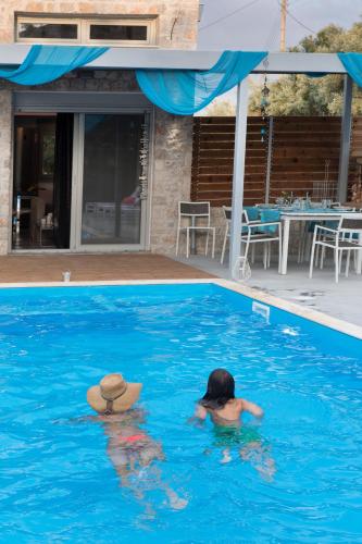 a person with a hat in a swimming pool at Lefkas Villas in Lygia