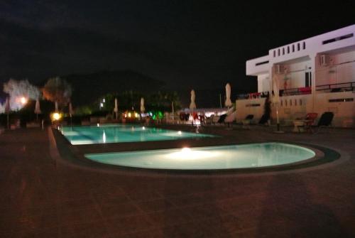 a couple of pools in a courtyard at night at Kokalakis Hotel in Kefalos