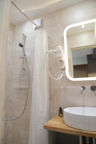 a bathroom with a shower and a sink and a mirror at H49 Apartman Wellness & Spa - Adults only in Sovata