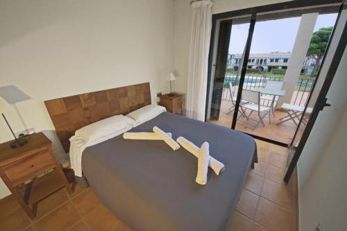 two crosses on a bed in a bedroom with a balcony at Bouganvilla in L'Ampolla