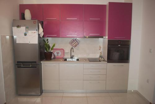 a kitchen with purple cabinets and a stainless steel refrigerator at Bisera in Skopje