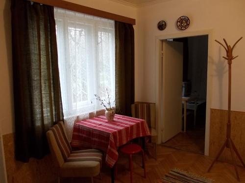 a dining room with a table and a window at Puszta Apartman A in Berekfürdő