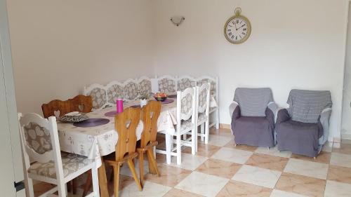 ein Esszimmer mit einem Tisch, Stühlen und einer Uhr in der Unterkunft Mama motel in Zánka