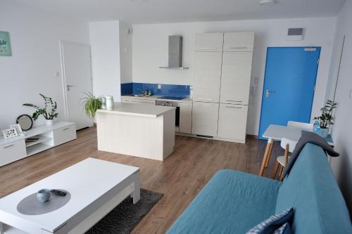 a living room with a blue and white kitchen at Cube Apartamenty in Lublin