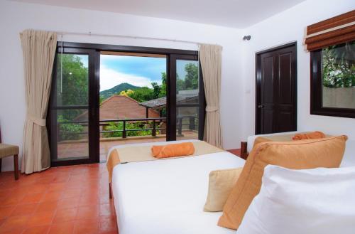 a bedroom with two beds and a large window at Villa Yao Yai in Choeng Mon Beach