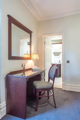 a desk with a chair and a mirror in a room at Cumbria Grand Hotel in Grange Over Sands