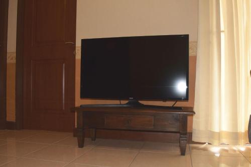 a flat screen tv sitting on top of a wooden table at Majesty Homey 2BR Apartment in Bandung
