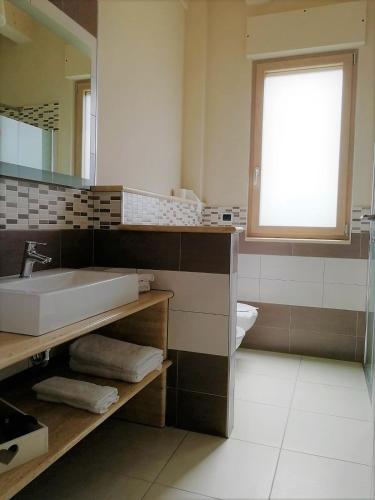 a bathroom with a sink and a mirror and a toilet at B & B Le due noci in Grottaminarda