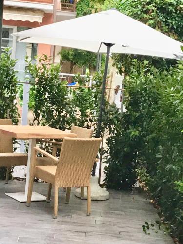 a wooden table and chairs under an umbrella at Appartamenti Barzilai in Gabicce Mare