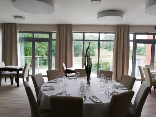 a dining room with a table and chairs and windows at Wielspin Puszczykowo in Puszczykowo