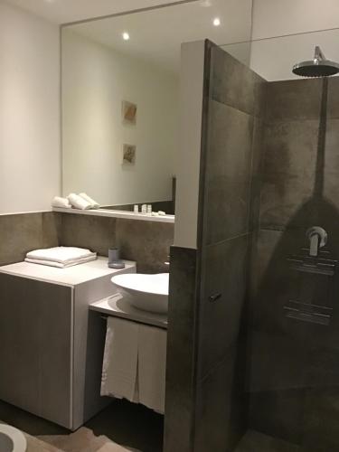 La salle de bains est pourvue d'un lavabo et d'une douche avec un miroir. dans l'établissement Appartamenti Barzilai, à Gabicce Mare