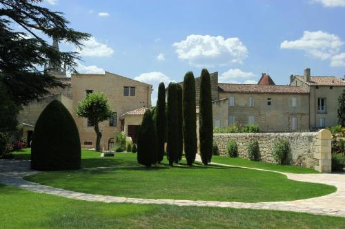 a row of trees in front of a building at Hôtel Au Logis des Remparts in Saint-Émilion