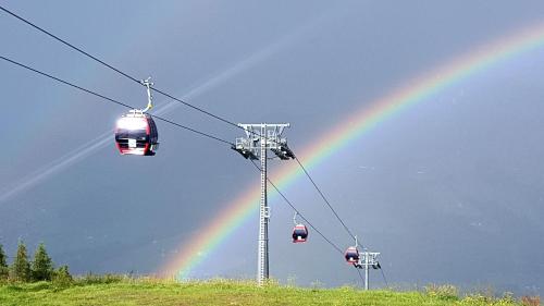 a rainbow in the sky over a ski lift at Berggasthof Schatzbergalm in Thierbach