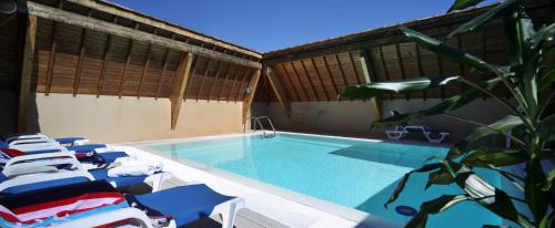 a swimming pool with lounge chairs next to a building at Best Western Le Pont d'Or in Figeac