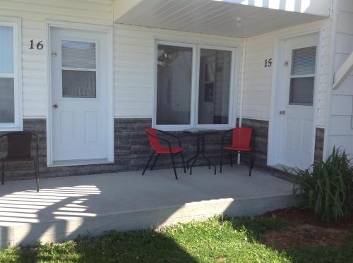 a porch with chairs and a table on a house at Les studios de la mer in Matane