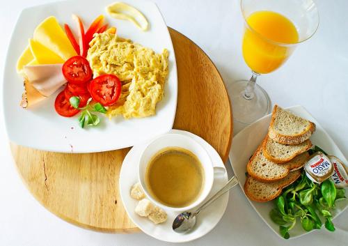 a table with a plate of food and a cup of coffee at IRS ROYAL APARTMENTS Apartamenty IRS Aviator in Gdańsk