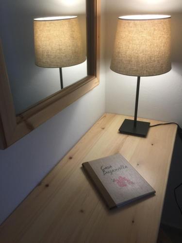 a table with two lamps and a book on it at Casa Buganvilla in Minia